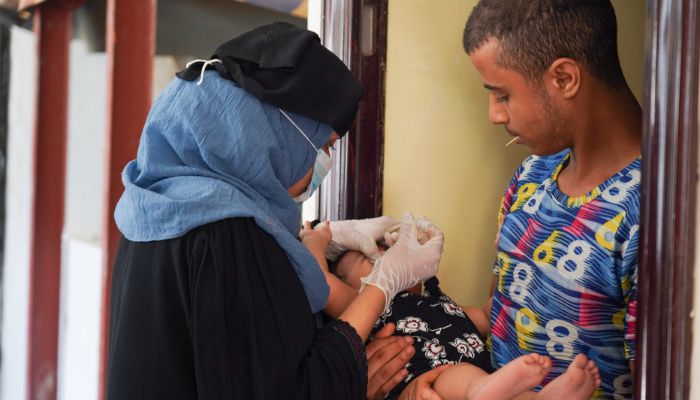 A vaccinator administering polio vaccine to a child during a vaccination campaign in Yemen, July 2020. — WHO