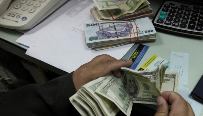 A currency exchange trader counts money at his office in Islamabad, on November 26, 2012. — Reuters