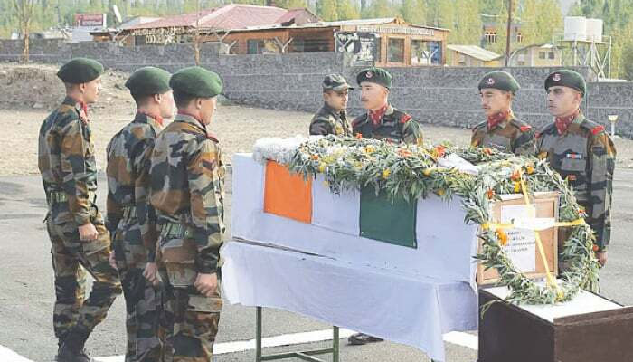 Indian soldiers stand in respect next to a coffin with the remains of Chander Shekhar.—AFP