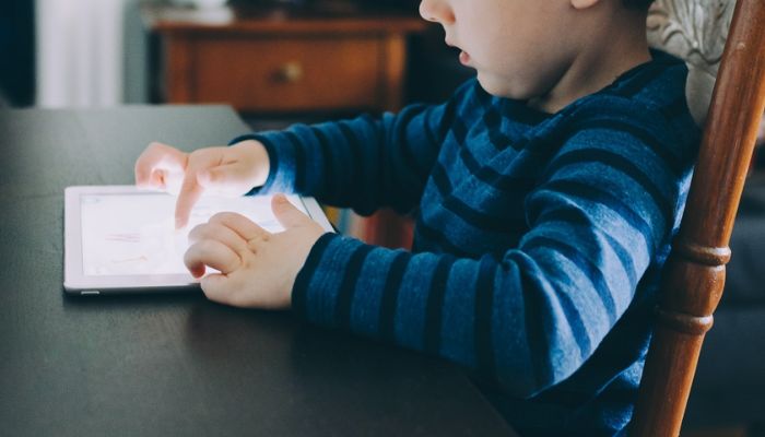 Kid using smart device.—Unsplash