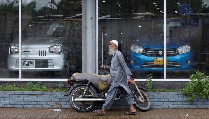 A man walks past a Suzuki outlet, displaying cars in Karachi, Pakistan, July 27, 2022.&mdash; Reuters/File