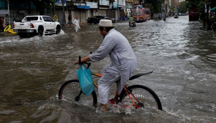 A man rides bicycle along a flooded road, following heavy rains during the monsoon season in Karachi, Pakistan July 25, 2022. Photo: Reuters