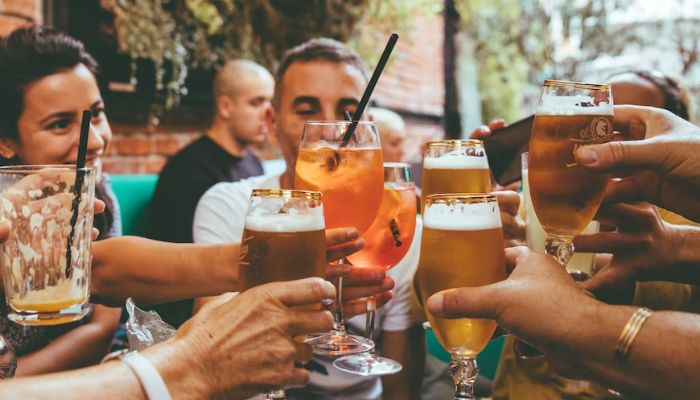 People clanking glasses of alcoholic drinks. — Unsplash