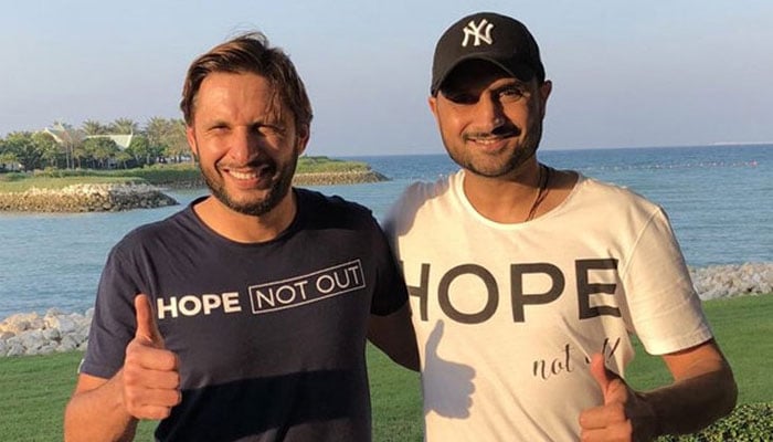 Shahid Afridi (left) and Harbhajan Singh all smiles while posing for a picture. — AFP