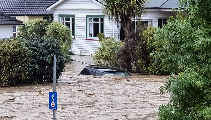 This handout picture taken on August 17, 2022, by local media outlet Andrew App and released on August 18 shows a flood-inundated car and homes from the overflowing Maitai River in central Nelson on New Zealands South Island. — AFP