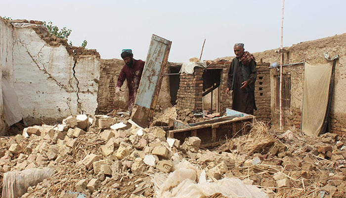Warga membersihkan puing-puing setelah atap sebuah rumah runtuh akibat hujan muson yang deras di pinggiran Quetta pada 5 Juli 2022. — AFP