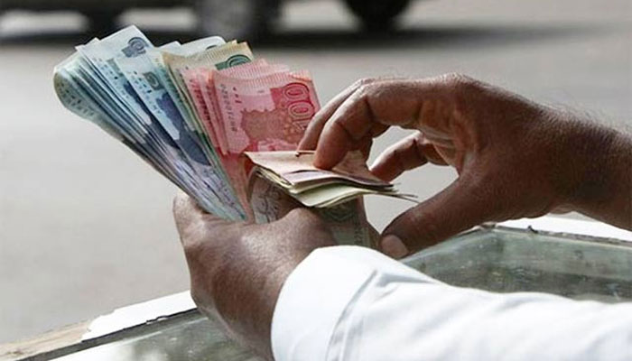 A trader counts rupee notes stacked together. — Reuters/File