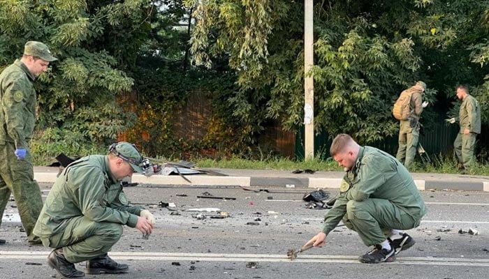 تفتیش کار مشتبہ کار بم حملے کی جگہ پر کام کر رہے ہیں جس میں 21 اگست 2022 کو روس کے ماسکو کے علاقے میں انتہائی قوم پرست روسی نظریاتی الیگزینڈر ڈوگین کی بیٹی دریا ڈوگینا ہلاک ہو گئیں۔