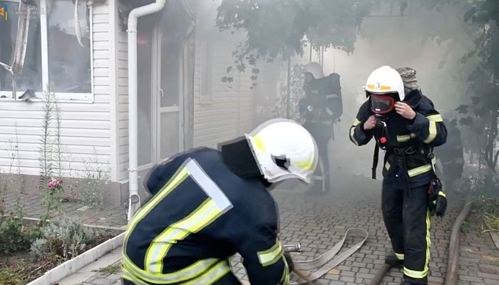فائر فائٹرز گولہ باری کے بعد عمارتوں میں لگی آگ کو بجھا رہے ہیں کیونکہ یوکرین پر روس کا حملہ جاری ہے، 6 اگست 2022 کو میکولائیو کے علاقے میں، ایک سوشل میڈیا ویڈیو سے حاصل کردہ اس اسکرین گریب میں۔  - رائٹرز