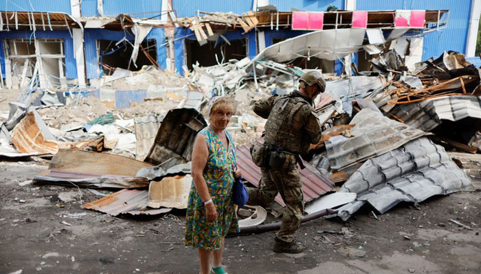 A woman stands next to a destroyed shopping center, as Russias attack in Ukraine continues, in Bakhmut, Donetsk region, Ukraine August 21, 2022. — Reuters