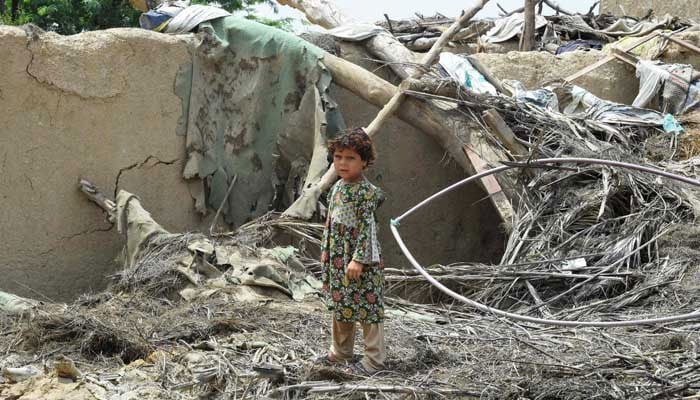 A girl stands over the debris of a damaged mud house at a flood affected town called Gandawah in Jhal Magsi district, Balochistan, on August 2, 2022. — AFP?File