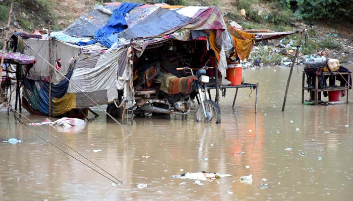 A view of huts submerged in the rainwater near a new bus stand after heavy rain in the city. — APP/File