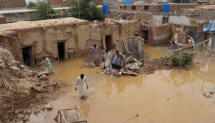 Residents clear debris of a damaged house due to a heavy monsoon rainfall on the outskirts of Quetta on July 5, 2022. — AFP