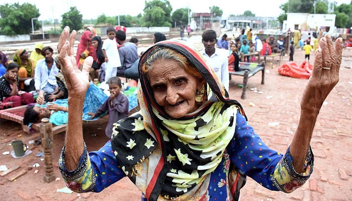 Large number of displaced people sit at a railway station in Godown. Larkana, Sindh. — APP