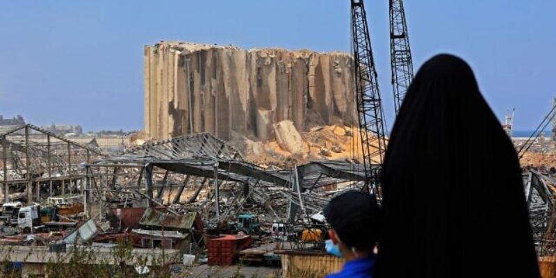 A woman and her son look at the damaged grain silos at the port of Beirut following a huge explosion that disfigured the Lebanese capital, August 12, 2020. — AFP