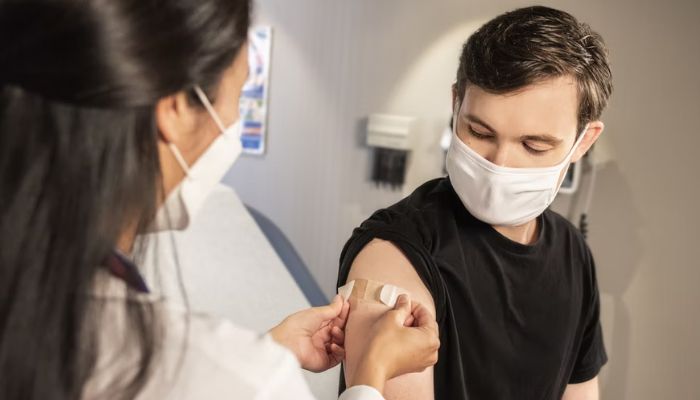 (Representational) A health care provider places a bandage on the injection site of a patient, who just received an influenza vaccine. —Unsplash