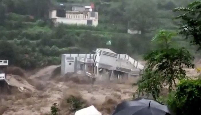 This screengrab shows a house being washed away in a massive flood.