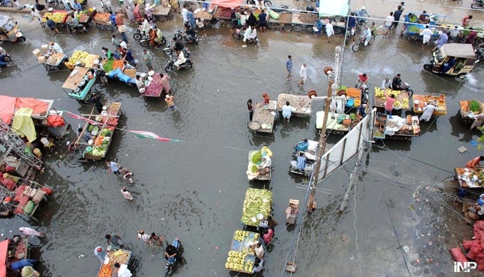 Vendors are facing difficulties due to accumulated flood water in Latifabad-11, as incessant rains in Hyderabad. — Online
