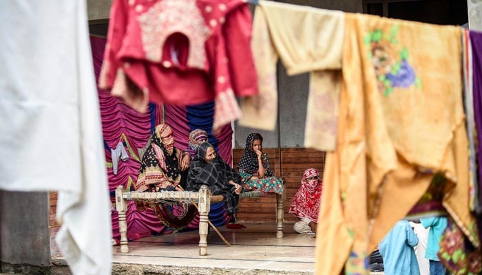 Displaced people take refuge inside a mosque after fleeing from their flood hit homes following heavy monsoon rainfalls in Sukkur of Sindh province, southern Pakistan on August 26, 2022. — AFP