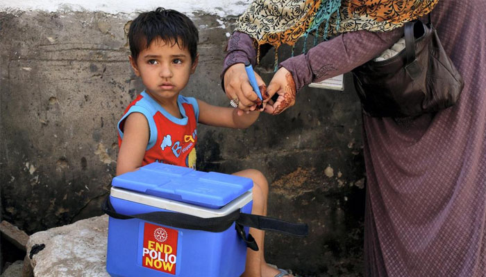 A health worker marks the hand of a child after administering an anti-poliovirus vaccine to him. — Reuters