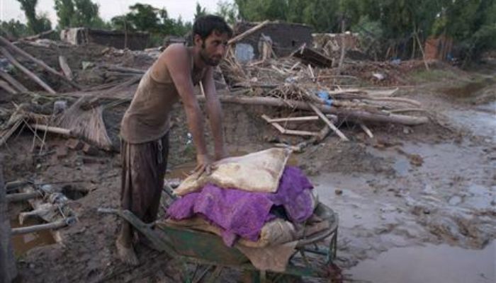 A flood victim takes a moment to rest while salvaging belongings through mud in his destroyed village in Pabbi, located in Pakistans northwest Khyber-Pakhtunkhwa Province August 4, 2010. — Reuters