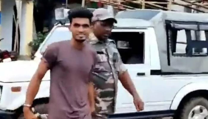 The accused, Shahrukh, smiles while being taken away by the police. — Screengrab via Twitter