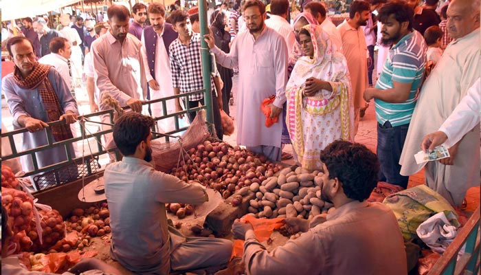People are busy is buying vegetables from a vendor at Sunday weekly bazaar in Federal Capital, as prices of various vegetables and fruits have massively surged in Punjab and other parts of the province and they are expected to increase further in the coming days due to short supply in markets and destruction of the crops by the floods in Balochistan and Sindh. — Online/File