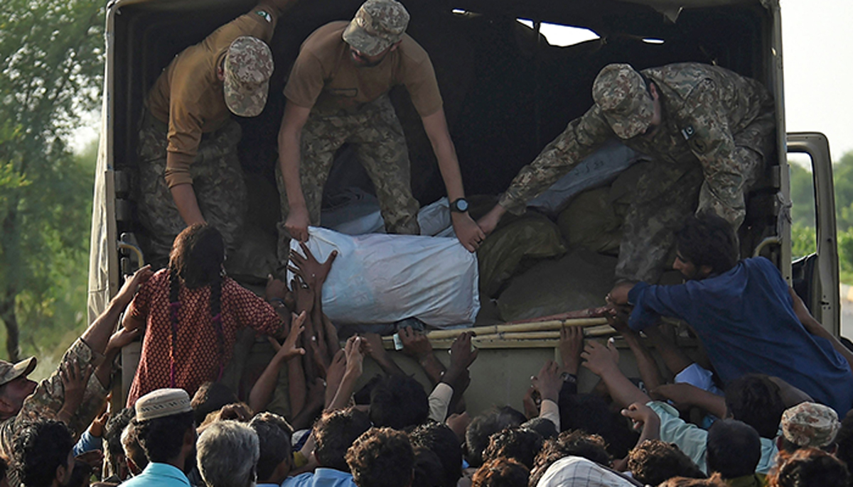 Army soldiers distribute relief food bags to flood-affected people in Shikarpur of Sindh province on August 28, 2022. — AFP