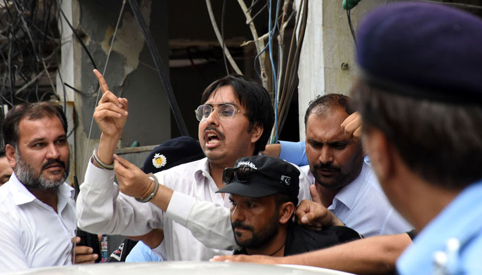 Police officers escort the leader of Pakistan Tehreek-e-Insaaf (PTI) Doctor Shahbaz Gill after a hearing at district court, in Federal Capital. — Online