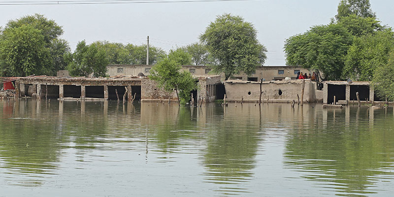 Women sit atop their mud house in a flood hit area following heavy monsoon rains in Dera Ghazi Khan district in Punjab province on August 29, 2022. — AFP