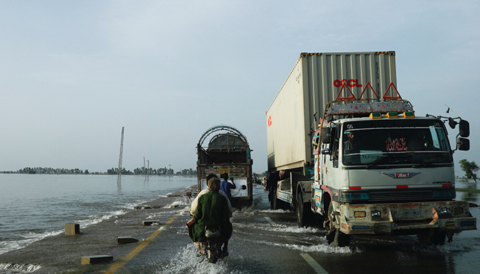 29 اگست 2022 کو میہڑ، پاکستان میں مون سون کے موسم کے دوران بارشوں اور سیلاب کے بعد گاڑیاں سیلاب زدہ سڑک کے ساتھ گزر رہی ہیں۔ - رائٹرز