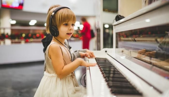 A girl learning to play piano. — Unsplash