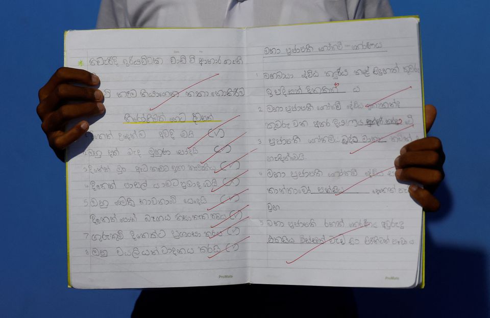 Sageeth Dinsara, 8, menunjukkan buku catatannya, di tengah krisis ekonomi negara, di Kolombo, Sri Lanka, 2 Agustus 2022. Mendidik anak-anak menjadi sangat sulit, kata kakek Dinsaras.  Selain melonjaknya harga dan pengeluaran lain untuk keluarga berpenghasilan rendah seperti kami, kendala terbesar adalah ongkos transportasi ke dan dari sekolah.  — Reuters