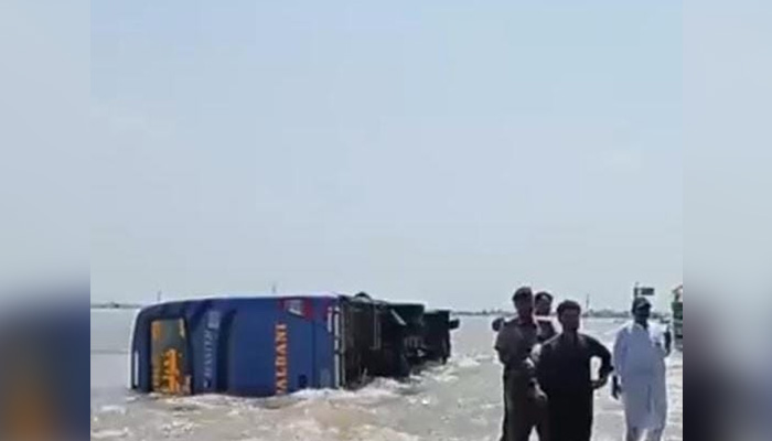 Image shows bus turning turtle in Dadu, Sindh amid flash flooding, on August 30, 2022. — Photo by author