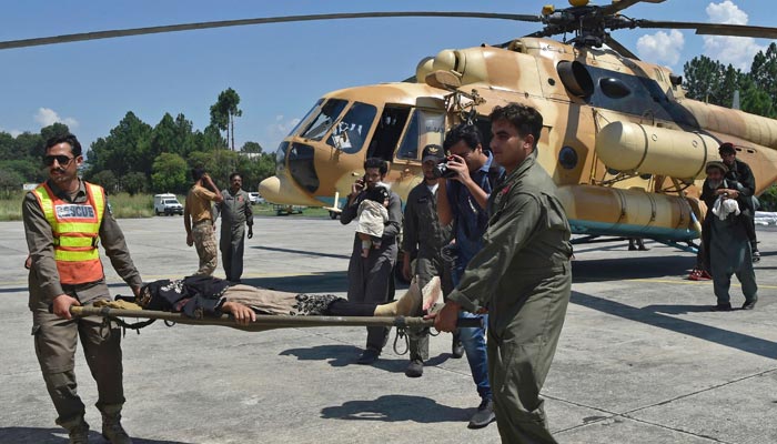 Pakistan´s army soldiers carry a stranded local tourist on a stretcher from an army helicopter after he was rescued from the flood-hit tourist area in Saidu Sharif, the capital of Swat valley in the Khyber Pakhtunkhwa province on August 30, 2022. — AFP