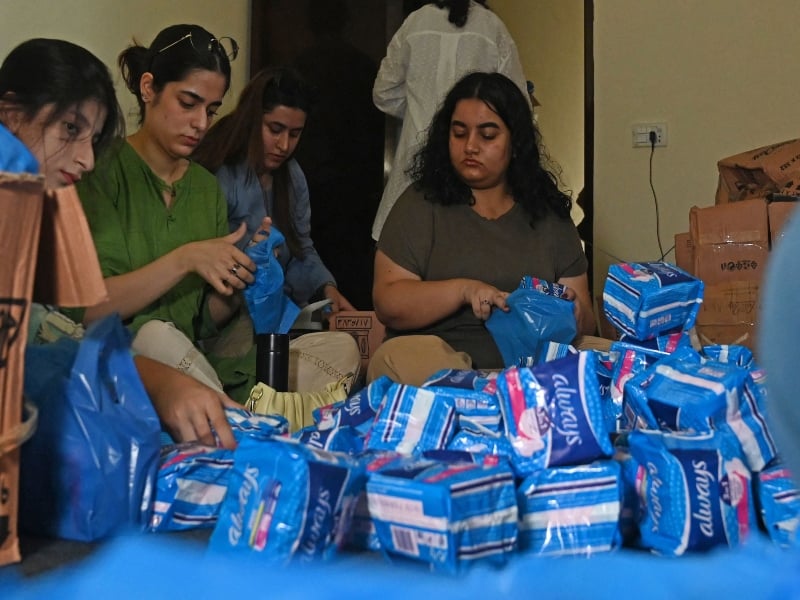 Members of a non-governmental organisation pack sanitary pads for women displaced by massive flooding, in Lahore on August 31, 2022.  — AFP/ Arif Ali