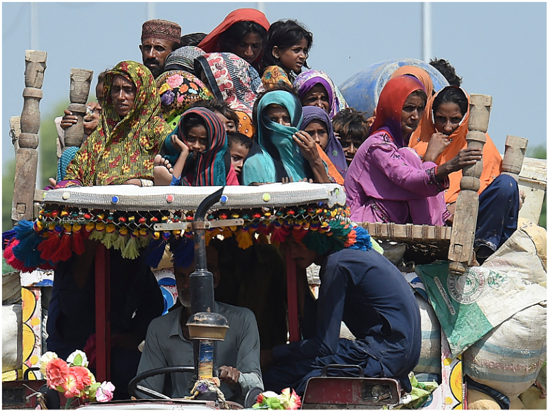 Displaced people arrive on a tractor with their belongings at a makeshift camp after fleeing from their flood-hit homes following heavy monsoon rains in Sukkur, Sindh province on August 29, 2022. — AFP/ Asif Hassan