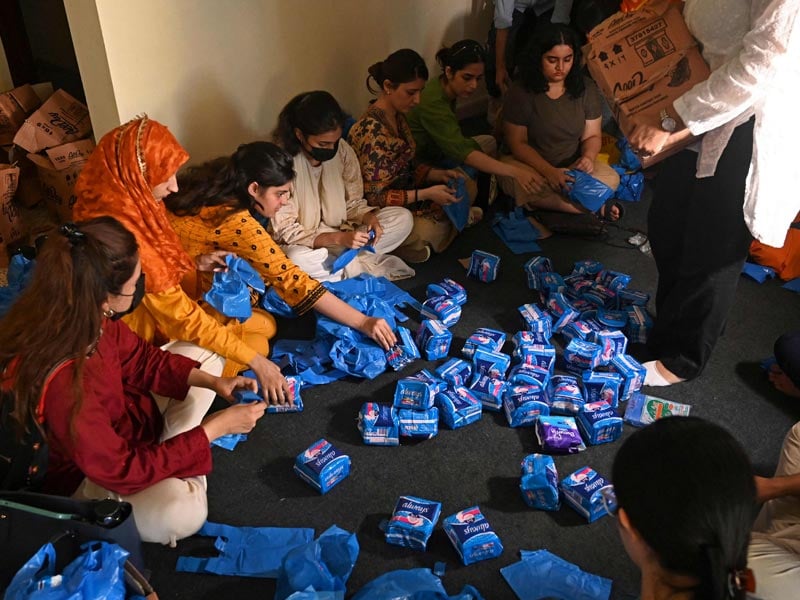 Members of a non-governmental organisation pack sanitary pads for women displaced by massive flooding, in Lahore on August 31, 2022. — AFP/ Arif Ali