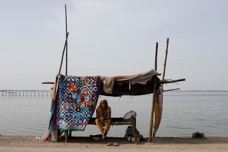 A flood victim takes refuge along a road in a makeshift tent, following rains and floods during the monsoon season in Mehar, Pakistan, August 29.