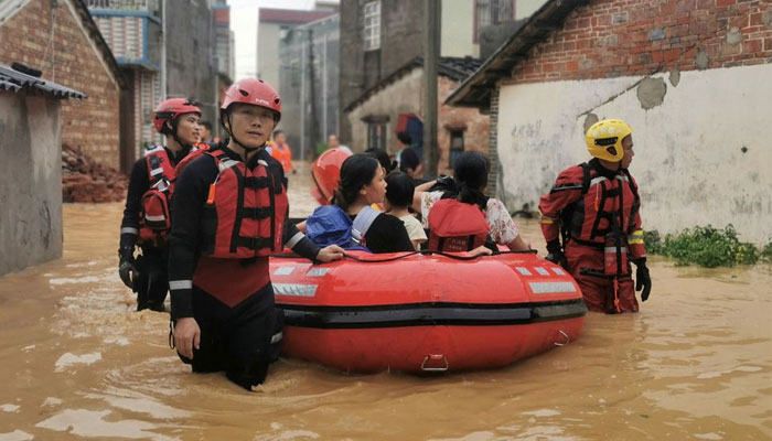 4 جولائی 2022 کو چین کے گوانگشی ژوانگ خودمختار علاقے بیہائی میں، ٹائفون چابا کی طرف سے آنے والی شدید بارشوں سے دیہاتوں میں سیلاب آنے کے بعد امدادی کارکن سیلاب سے متاثرہ رہائشیوں کو ڈنگی کے ساتھ نکال رہے ہیں۔ — رائٹرز
