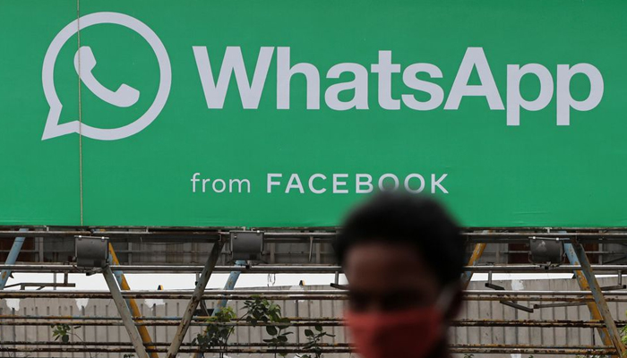 A man walks past a hoarding of the WhatsApp application installed at a skywalk in Mumbai, India, August 26, 2021. — Reuters