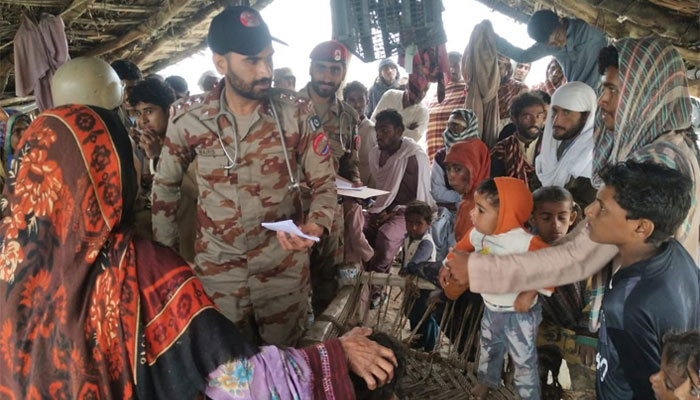 An army doctor inquires after flood victims in a makeshift camp. &mdash; ISPR/File