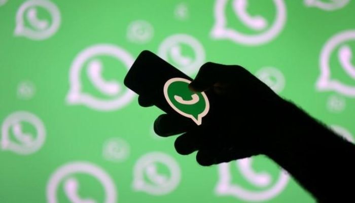 A man poses with a smartphone in front of displayed Whatsapp logo in this illustration September 14, 2017.— Reuters
