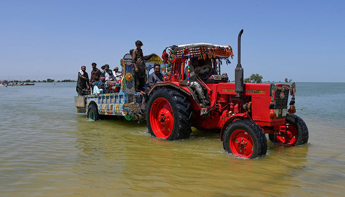 Villagers board a tractor trolley as they travel amid flood water, following rains and floods during the monsoon season in Bajara village, Sehwan, Pakistan, August 31, 2022. — Reuters