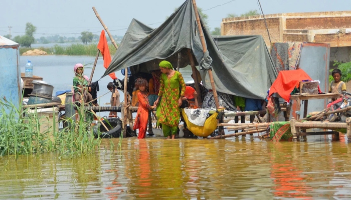A flood-hit family lives in a makeshift shelter on inundated land. — AFP/File