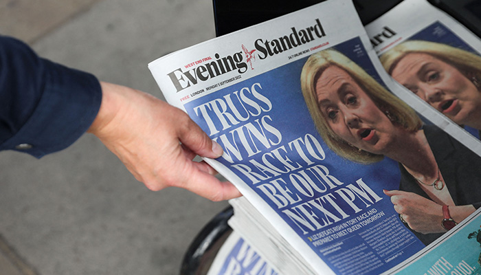 A person takes a copy of the British newspaper Evening Standard picturing Britain´s New Conservative Party leader and incoming prime minister Liz Truss following her election, London on September 5, 2022. — AFP