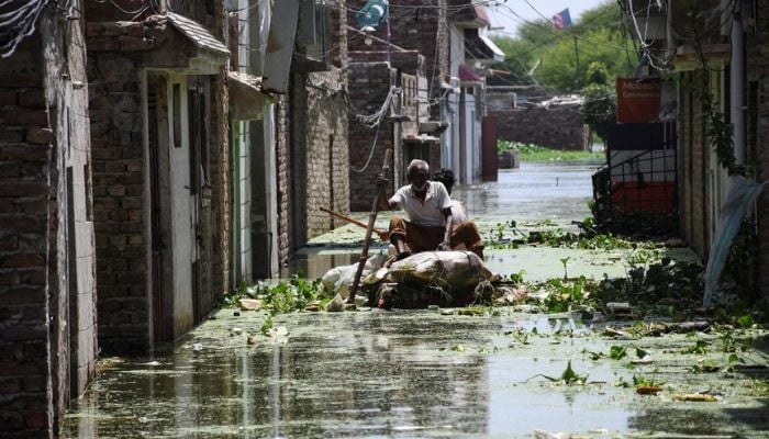 Men use a makeshift raft as they cross a flooded street in a residential area, following rains during the monsoon season in Hyderabad, Pakistan September 5, 2022. — Reuters