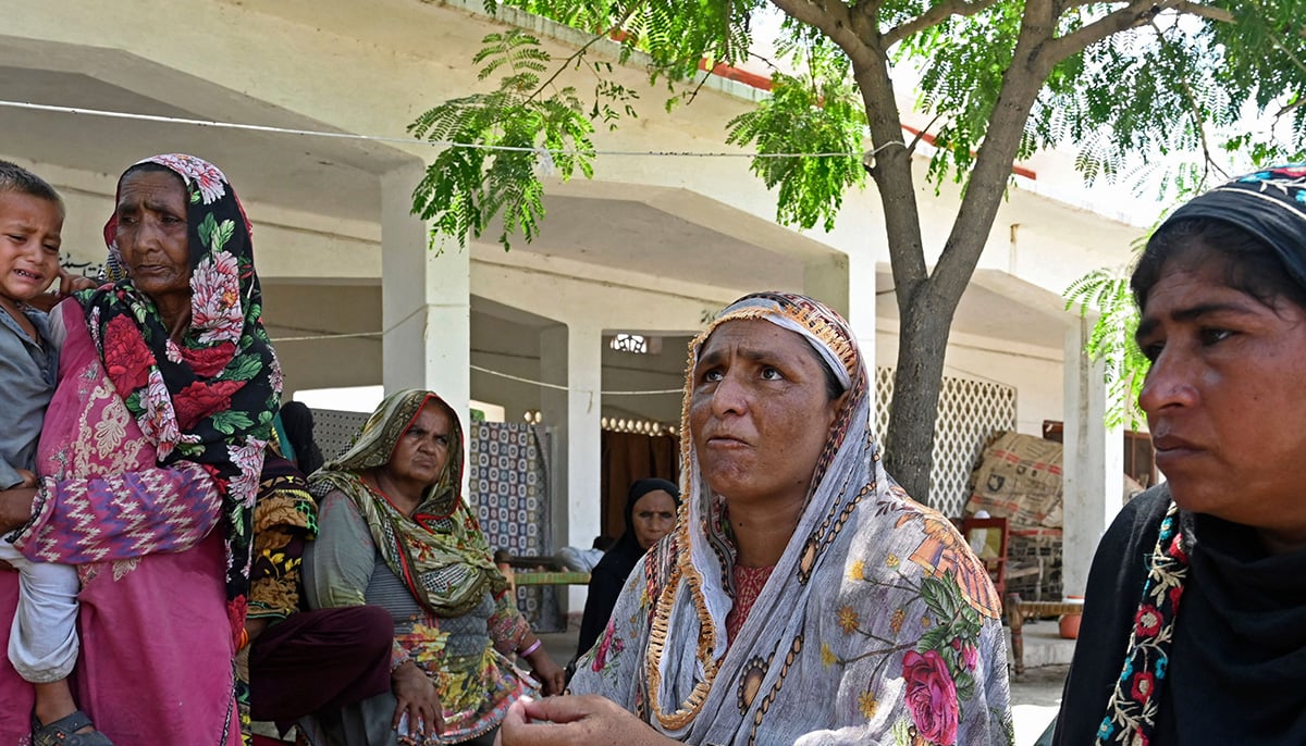 3 ستمبر 2022 کو لی گئی اس تصویر میں، ایک سیلاب سے متاثرہ خاتون زیبونیسہ بی بی صوبہ پنجاب کے ضلع راجن پور کے فاضل پور میں واقع ایک عارضی کیمپ میں AFP کے ساتھ اپنے ٹوائلٹ کے مسائل کی وضاحت کے لیے بات کر رہی ہے۔  - اے ایف پی