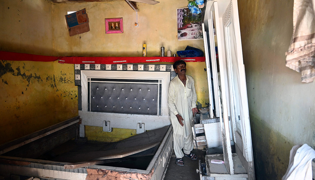 Mureed Hussain looks at the dowry furniture of his daughter´s wedding which was damaged by flood waters at his house in Fazilpur, Rajanpur district of Punjab province on September 3, 2022. — AFP