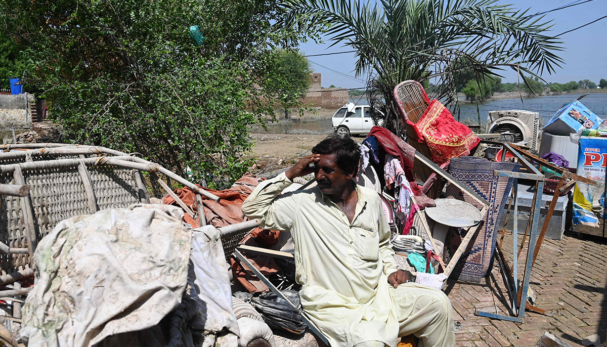 Mureed Hussain sits with the dowry furniture of his daughter Nousheen, which was damaged by flood waters at his house in Fazilpur, Rajanpur district of Punjab province on September 3, 2022. — AFP